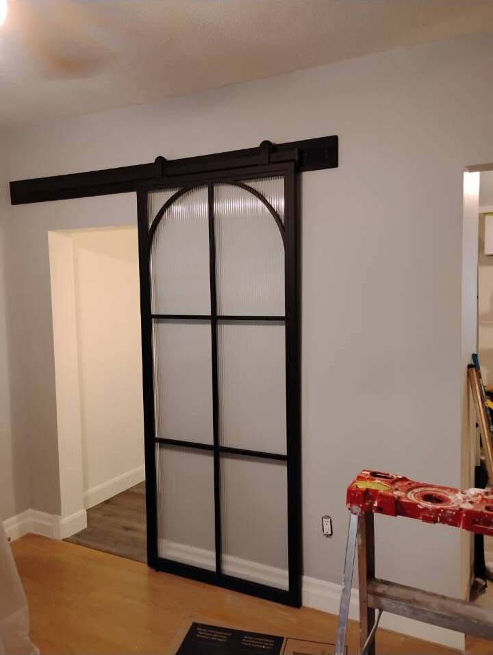 Black-framed sliding barn door installed during an interior renovation