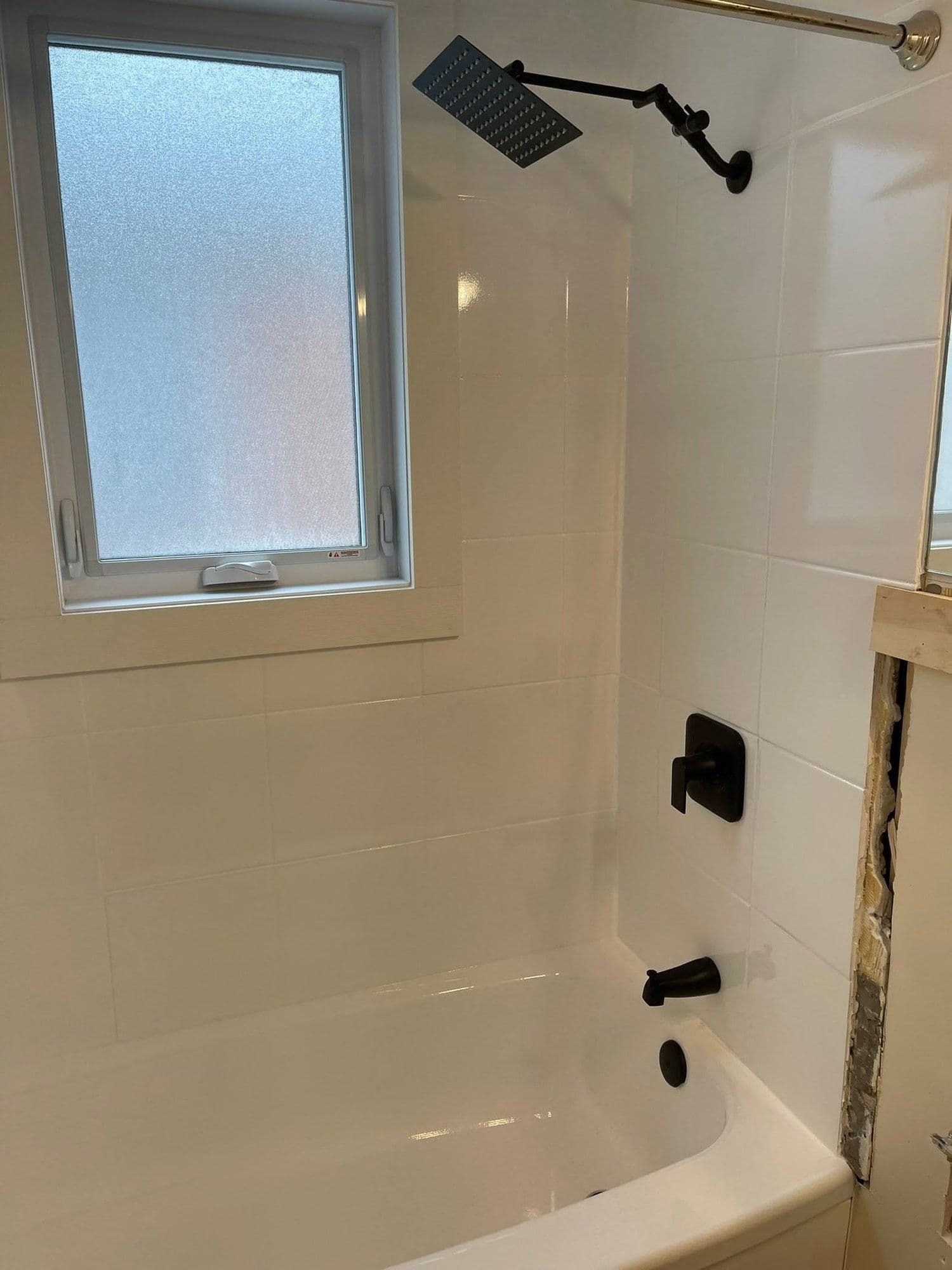 White tub surround with matte black rainfall shower fixtures