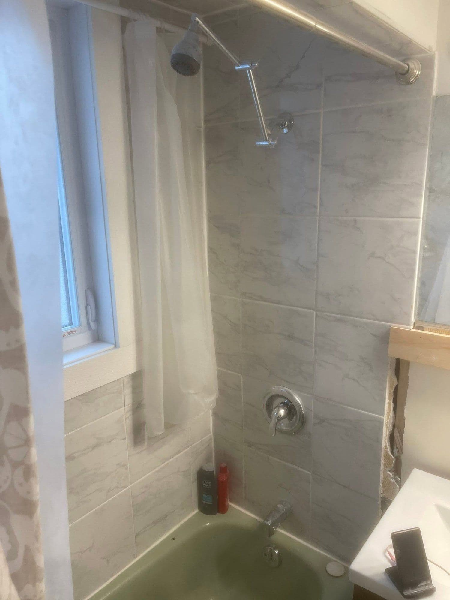 Tub surround retiled in large-format grey marble-look tile