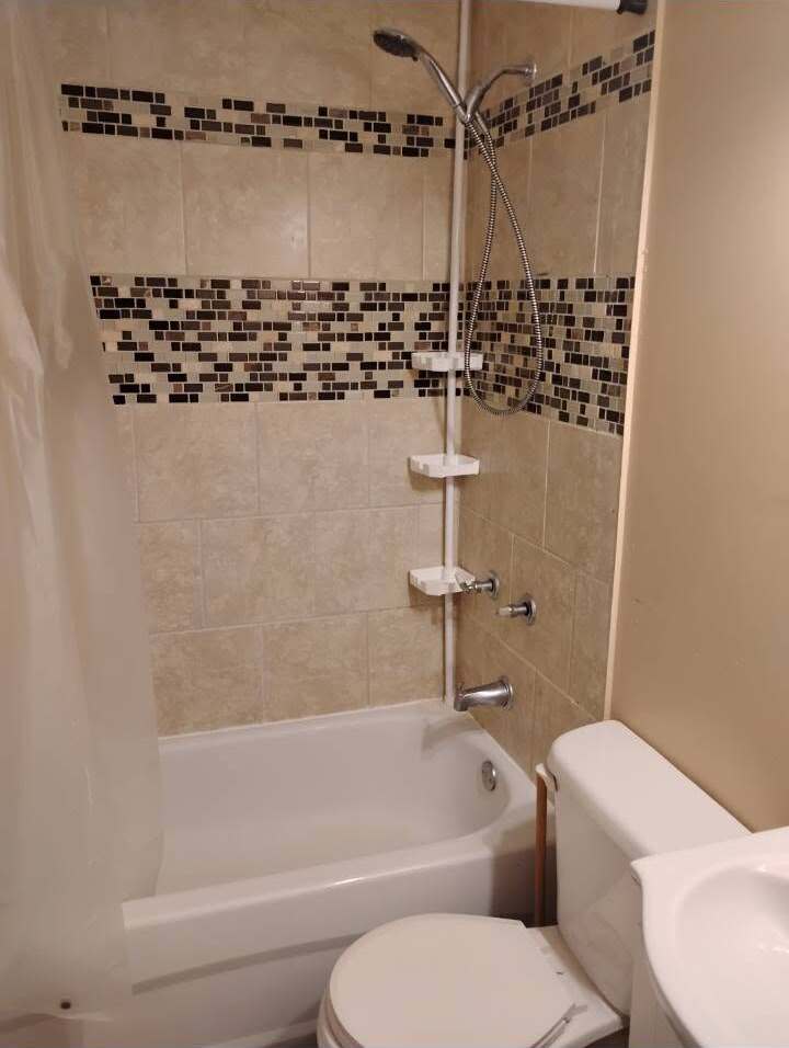 Renovated bathtub surround with glass mosaic accent band