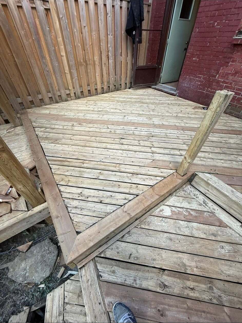 Weathered deck boards being assessed before a rebuild