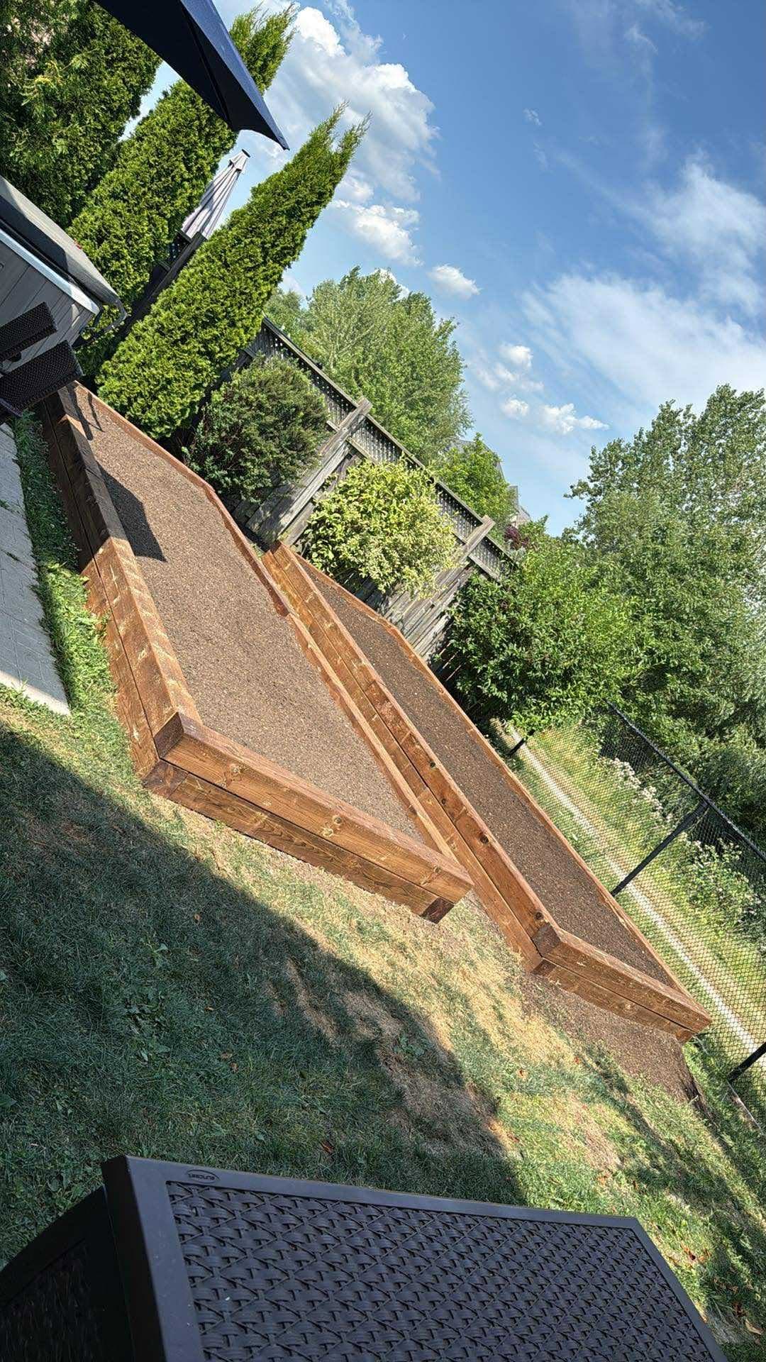 Long cedar garden box built along a backyard fence line