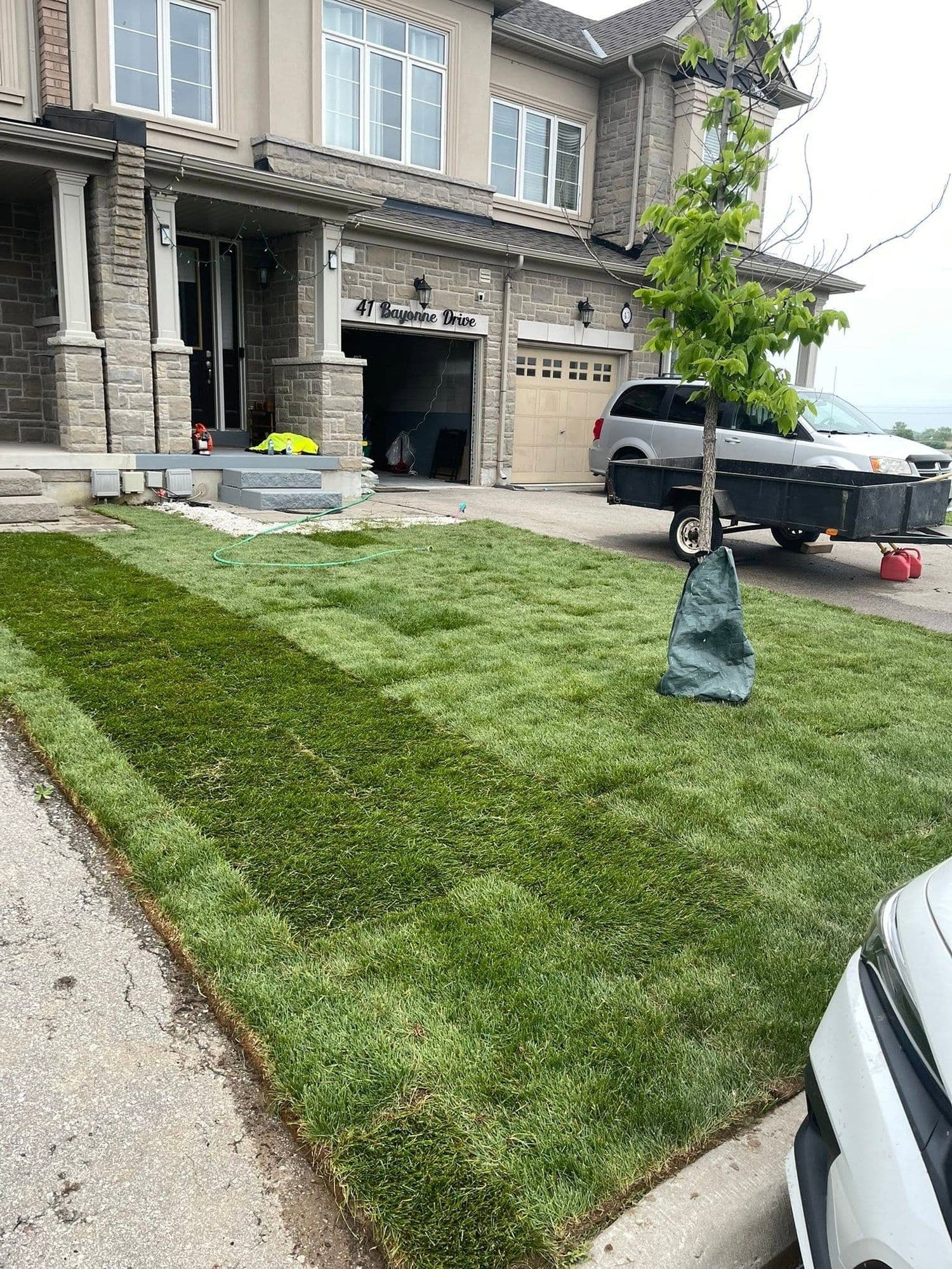 Fresh sod rows installed across a front yard in a new subdivision