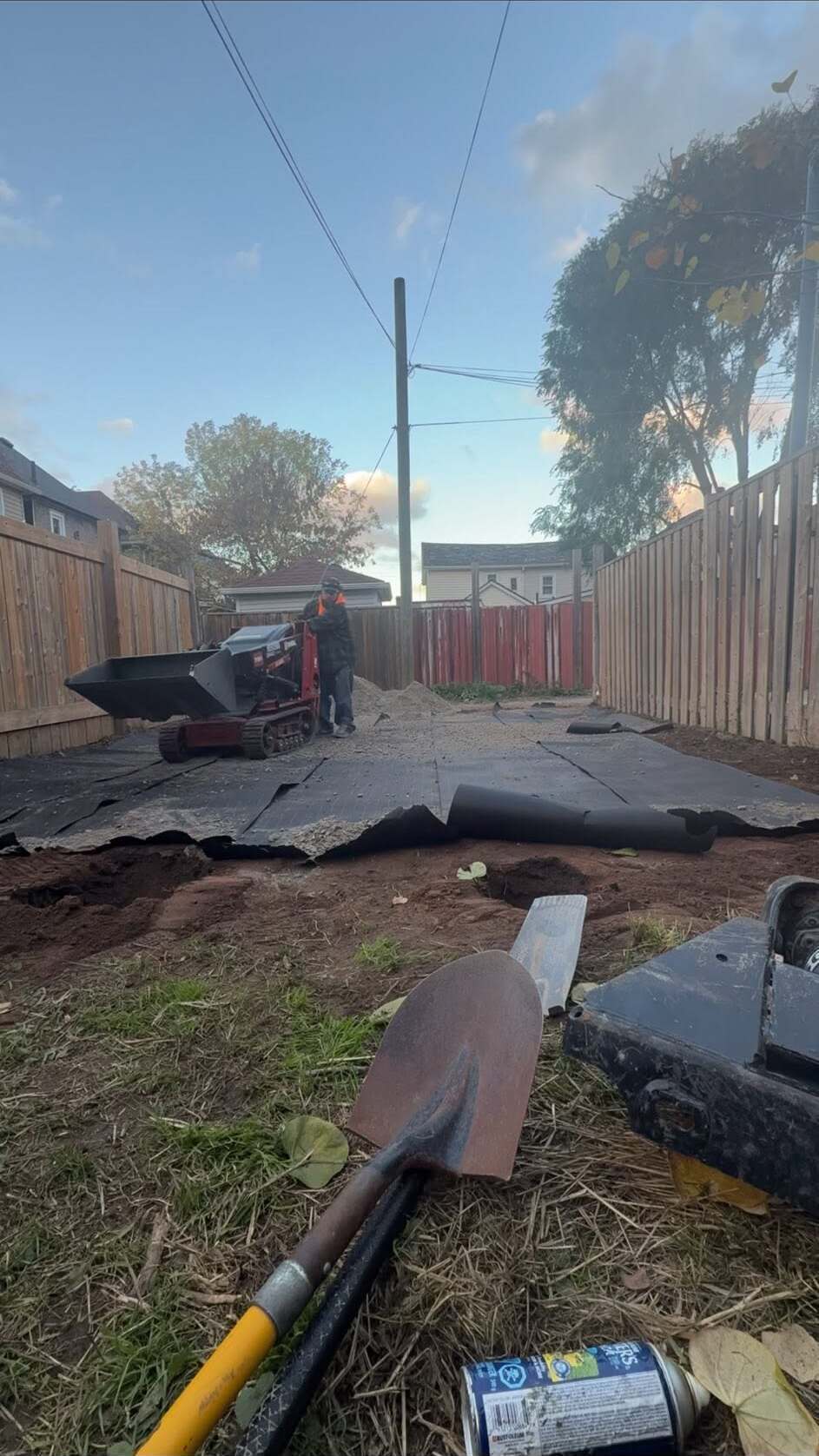Yard mid-grading with landscape fabric and compact loader